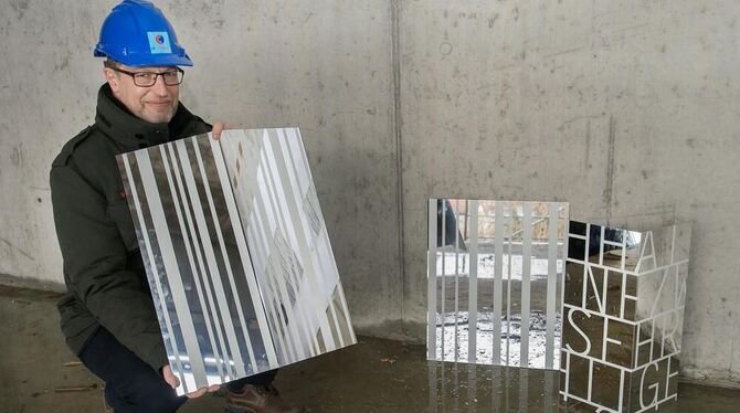 Peter Gebert, stellvertretender Leiter des Gebäudemanagements, mit einem Muster der beschlossenen Klebestreifen-Fassade.
