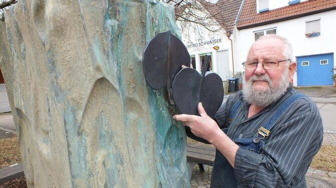 Am alten Lindenbrunnen: Kunstschmied Paul Zimmermann mit zwei der bereits geschmiedeten stilisierten Lindenblätter, die einmal,