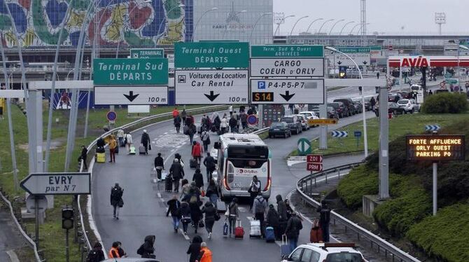 Reisende laufen am Samstag mit Gepäck über die Autobahn zum Pariser Flughafen Orly. Nach dem Zwischenfall war der Luftverkehr