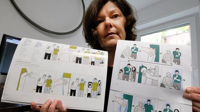 Christina Heiligensetzer, Vorstand im Verein Bild und Sprache, zeigt in ihrem Büro in Stuttgart  zwei grafisch ähnliche Bildgesc