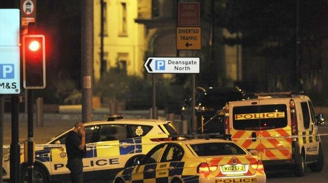 Polizeifahrzeuge blockieren eine Straße in der Nähe der Manchester Arena. Foto: Rui Vieira/AP/