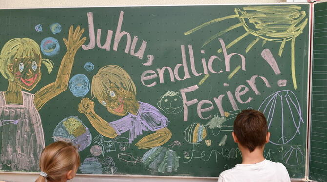 Erst- und Zweitklässler malen in der Grundschule in Weißenau bei Ravensburg am letzten Schultag des Jahres für den Fotografen ei