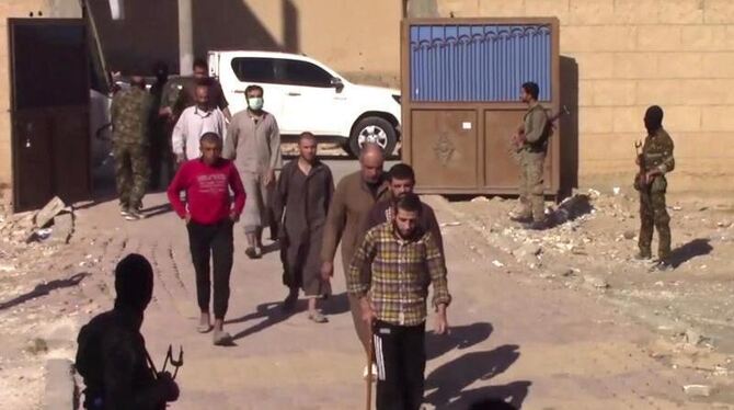 Kämpfer der Terrormiliz Islamischer Staat (IS), die sich ergeben haben und in einer Basis der Syrischen Demokratischen Kräfte
