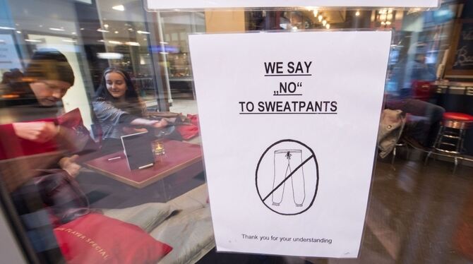 Ein Schild mit der Aufschrift »We say «no» to sweatpants - Thank you for your understanding« hängt in Stuttgart an der Eingangst