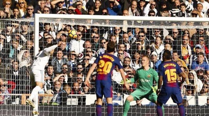Cristiano Ronaldo (l) köpft den Ball auf das Tor mit Marc-Andre ter Stegen vom FC Barcelona. Foto: Enrique de la Fuente