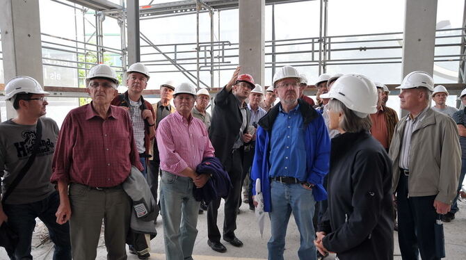 Projektleiter Klaus Kessler (mit rotem Bauhelm) zeigt GEA-Lesern die Stadthallen-Baustelle. FOTO: Niethammer