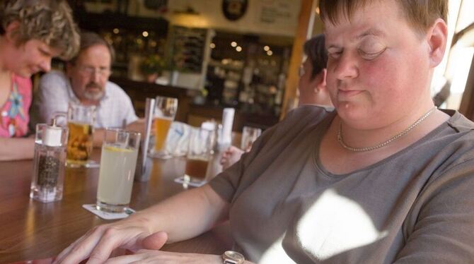 Simone Degler liest in der Bahnhofsgaststätte in Tübingen die geprägte Seite einer Speisekarte für Blinde. FOTO: SCHREIER Simone Degler liest in der Bahnhofsgaststätte in Tübingen die geprägte Seite einer Speisekarte für Blinde. FOTO: SCHREIER