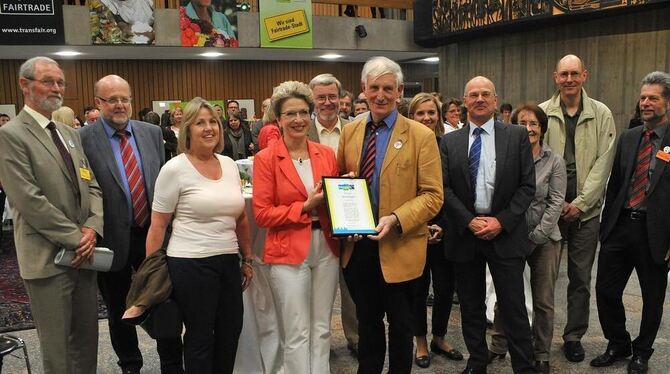 Barbara Bosch und Manfred Holz von Fairtrade Deutschland mit der Urkunde. Sie werden eingerahmt von Mitgliedern der Steuerungsgr