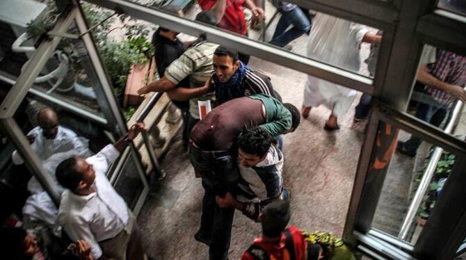 Ein Verletzter wird zur Behandlung in ein Gebäude getragen. Foto: Mosaab Elshamy
