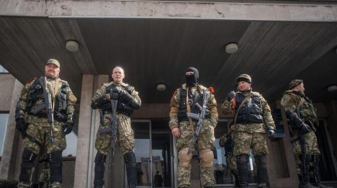 Bewaffnete ostukrainische Separatisten bewachen die besetzte Polizeistation von Slawjansk. Foto: Roman Pilipey