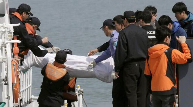 Die ersten Opfer des Fährunglücks werden aus dem untergegangenen Schiff geborgen. Foto: Kimimasa Mayama