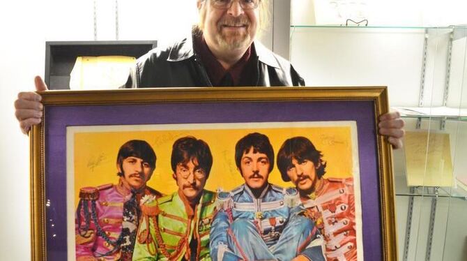 Beatles-Experte Garry Shrum mit einem Poster, auf dem die Beatles unterschrieben haben. Foto: Chris Melzer