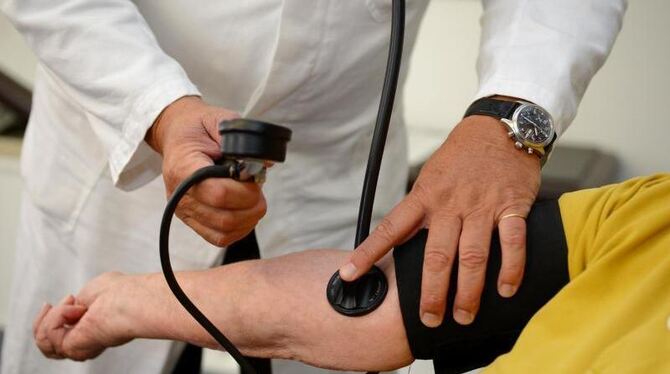 Ein Hausarzt beim Blutdruckmessen.