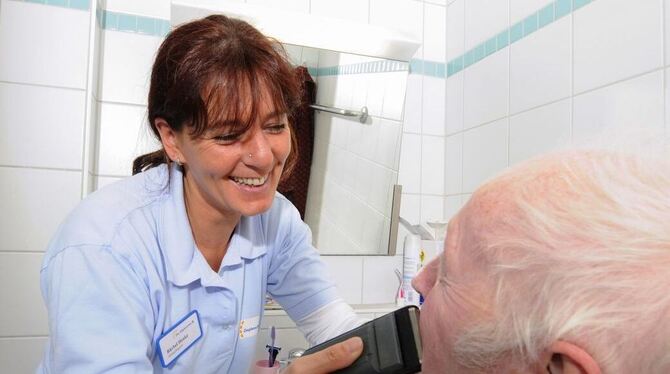 Eine Pflegerin hilft einem Bewohner im Kusterdinger Gemeindepflegehaus Härten bei der Rasur.  FOTO: PR