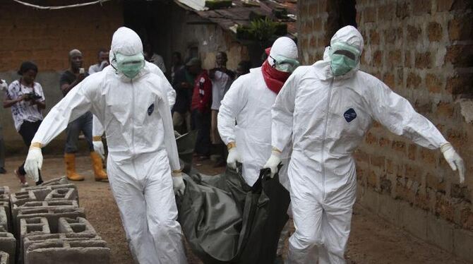 Helfer bergen in Liberia die Leiche eines Ebola-Opfers. Foto: Ahmed Jallanzo