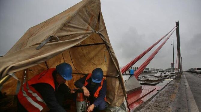 Arbeiter reparieren auf der maroden Rheinbrücke der Autobahn A1 in Leverkusen die Halterungen der Stahlseile. Foto: Oliver Be