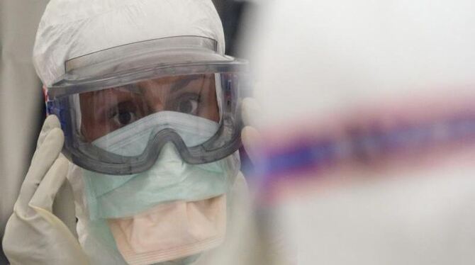 Eine Mitarbeiterin von Ärzte ohne Grenzen legt Schutzkleidung an, die vor einer Infektion mit Ebola schützen soll. Foto: Olvi
