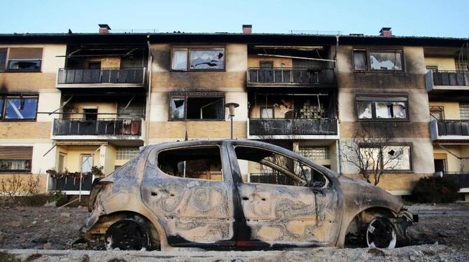 Ausgebrannte Autos stehen vor der zerstörten Fassade eines Wohnhauses. Foto: Fredrik von Erichsen