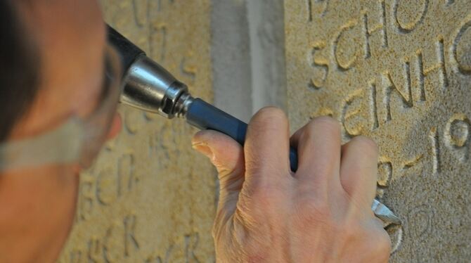 Der Steinmetz erfüllt eine uralte Aufgabe: Die Namen der Eninger Pfarrer werden im Kirchenschiff konserviert. FOTO: SEITZ