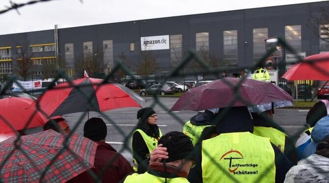 Streikende Amazon-Mitarbeiter stehen vor dem Eingang zum Amazon-Logistikzentrum im hessischen Bad Hersfeld. Foto: Uwe Zucchi