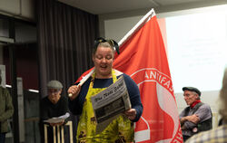 Links und rechts eine rote Fahne: Claudia Jochen zeigt die Insignien der Arbeiterbewegung. Im Hintergrund Ursel Reutter und Jürg