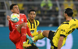 Münchens Jamal Musiala (links) und Dortmunds Emre Can (rechts) kämpfen um den Ball. In der Mitte Dortmunds Jude Bellingham. Beid