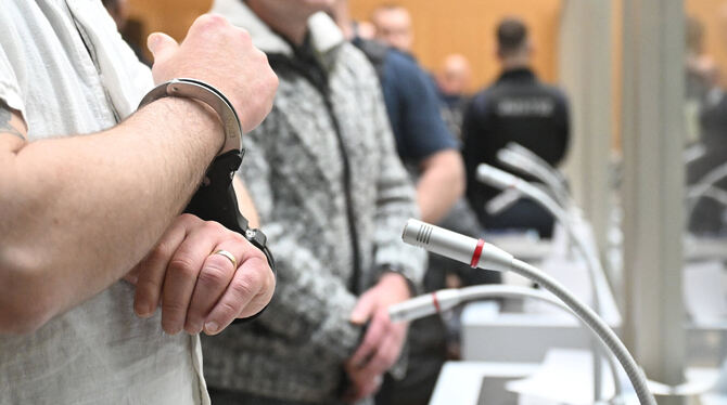 In Handschellen und hinter dickem Glas: Die Angeklagten eines Prozesses in Stuttgart sind stark gesichert.