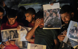 Ein schiitischer Muslim weint, während er Fotos des iranischen Präsidenten Ebrahim Raisi bei einer Mahnwache hochhält.