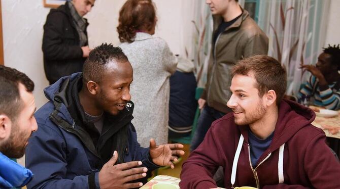 Hans Bächle (rechts) im angeregten Gespräch mit Asylcafé-Besuchern. Das Thema? Fußball natürlich.  GEA-FOTOS: PACHER