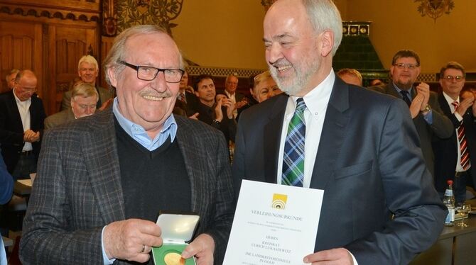 Ulrich Lukaszewitz (links) erhielt die goldene Landkreismedaille aus den Händen von Landrat Thomas Reumann.  FOTO: KUS