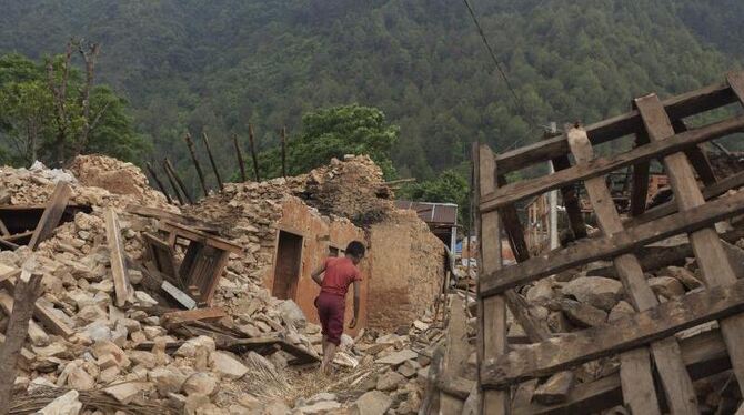 Ein Junge sucht sich am Rande von Kathmandu durch Trümmer von beim April-Beben zerstörten Häuser seinen Weg. Foto: Hemanta Sh