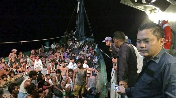 Ein Boot mit aus Myanmar geflüchteten Rohingya neben einem Schiff der thailändischen Marine. Foto: Royal Thai Navy