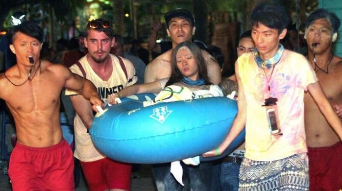 Helfer bringen eine junge Frau im »Formosa Water Park« zu einem Krankenwagen. Foto: Stringer/dpa