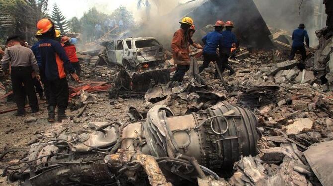 Rettungskräfte untersuchen die Trümmer des abgestürzten Militärtransporters. Foto: Dedi Sahputra