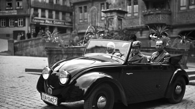 Das Werksfoto aus dem Jahr 1936 zeigt Ferry Porsche am Steuer des zweiten Volkswagen-Prototypen (V2), fotografiert auf dem Markt