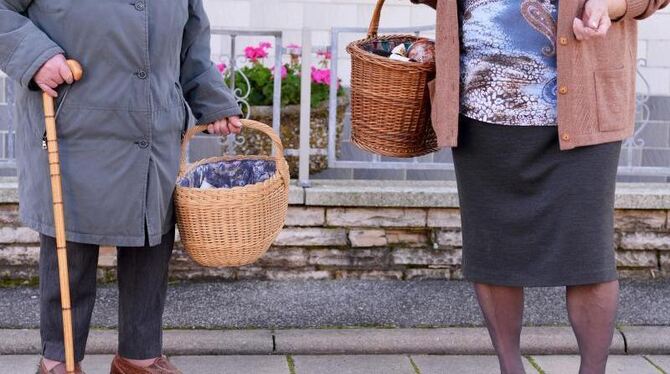 Zwei ältere Damen tragen nach einem Einkauf ihre Lebensmittel nach Hause. Foto: David Ebener/Illustration