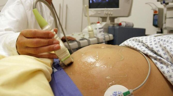 Eine Hebamme führt in einer Frauenklinik an einer schwangeren Patientin eine Ultraschall-Untersuchung durch. Foto: Daniel Kar