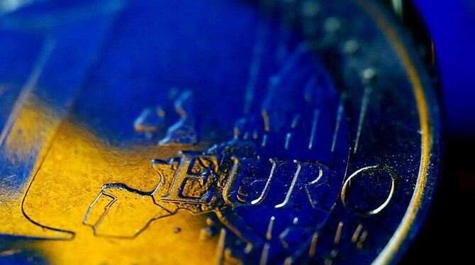 Die Fahne der Europäischen Union (EU) spiegelt sich in einer Euro-Münze. Foto: Oliver Berg /Illustration