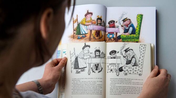 Eine Frau hält eine alte (vorn) und eine neue Ausgabe des Kinderbuchs »Jim Knopf und die wilde 13« des Autors Michael Ende in de Eine Frau hält eine alte (vorn) und eine neue Ausgabe des Kinderbuchs »Jim Knopf und die wilde 13« des Autors Michael Ende in de