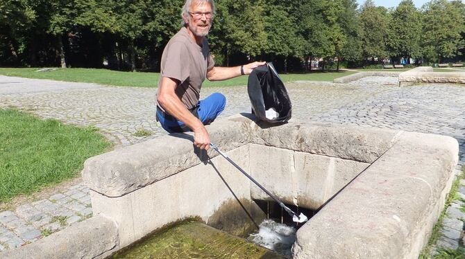 Handarbeit: Mit einem Zwacker angelt Leonhard Bonow Dreck aus dem Wasserlauf im Volkspark.