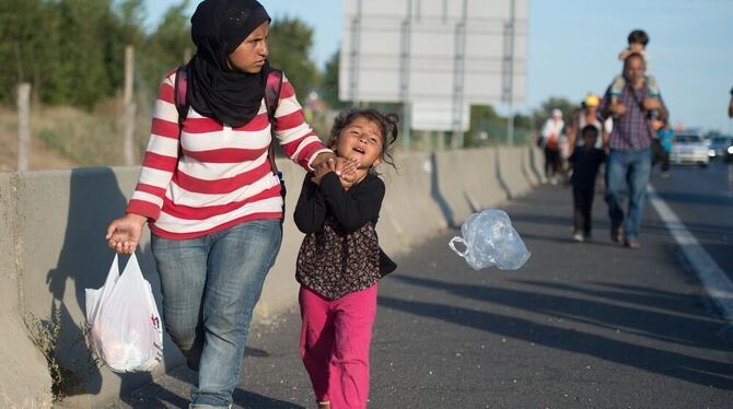 Hunderte Flüchtlinge aus Syrien, dem Irak und Afrika laufen bei Budapest (Ungarn) über eine Autobahn in Richtung der Grenze zu Ö