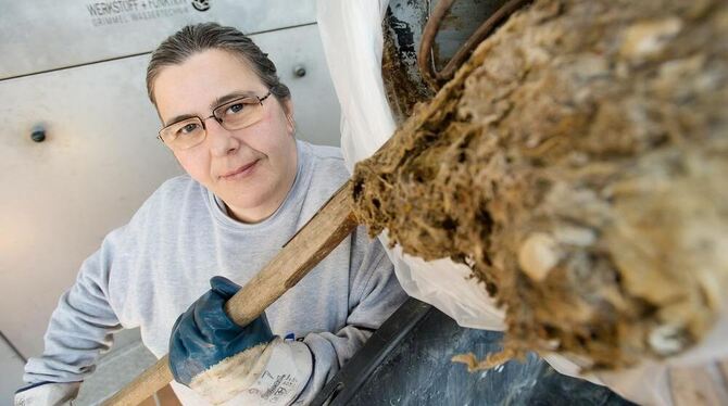 Regine Labenda holt mit einem Rechen getrocknete Abfälle aus einem Rohr. FOTO: TRINKHAUS Regine Labenda holt mit einem Rechen getrocknete Abfälle aus einem Rohr. FOTO: TRINKHAUS