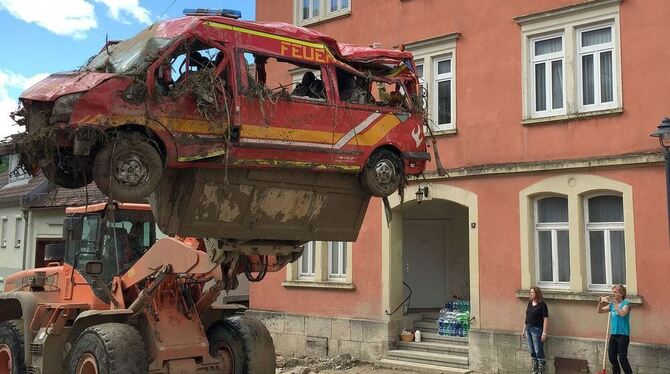 Ein bei einer schweren Überschwemmung verunglücktes Feuerwehrfahrzeug wird   in Braunsbach bei Aufräumarbeiten abtransportiert.