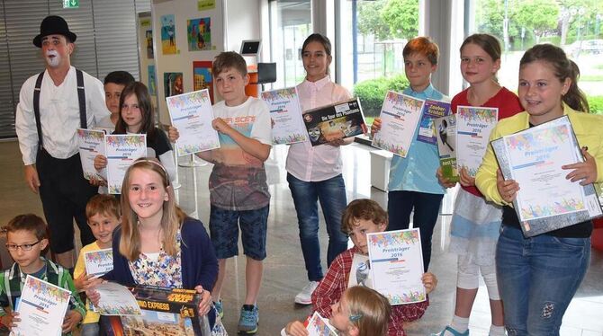 Die glücklichen jungen Gewinner des Malwettbewerbs im Bereich der Volksbank Ermstal-Alb mit Urkunde und Präsenten.  FOTO: SANDER