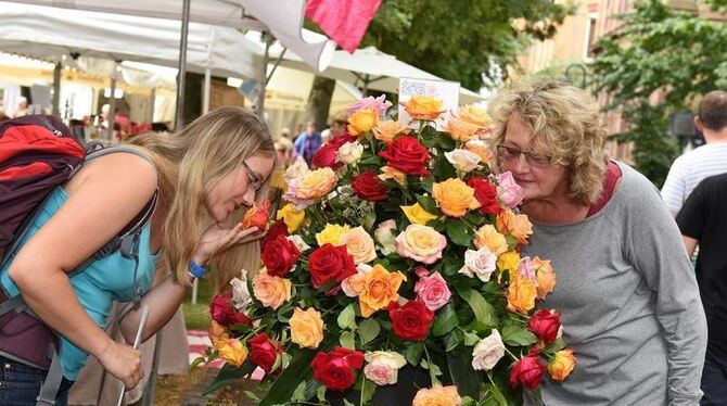 Einfach dufte finden diese beiden Besucherinnen des Neigschmeckt-Marktes die blumigen Auslagen eines Beschickers, der Rosen-Produkte anbietet.