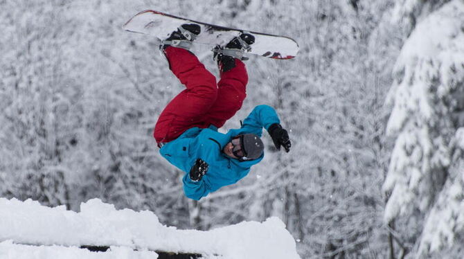 Ein Snowboardfahrer springt auf dem Feldberg im Schwarzwald durch die Luft.