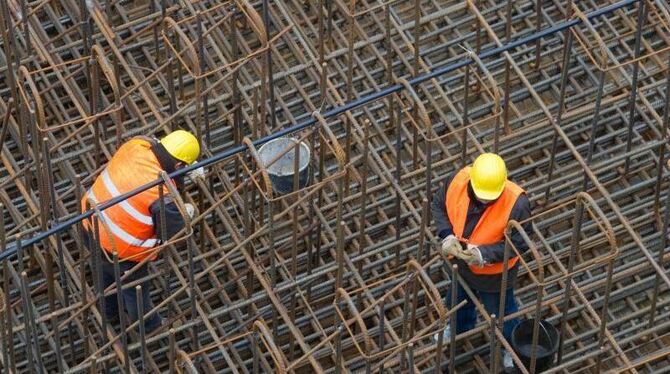Bauarbeiter errichten ein Stahlgeflecht. Der Gehaltsunterschied im mittleren Einkommen zwischen deutschen und ausländischen A