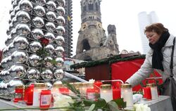 Eine Passantin legt in Berlin am Ort des Anschlags Blumen nieder.