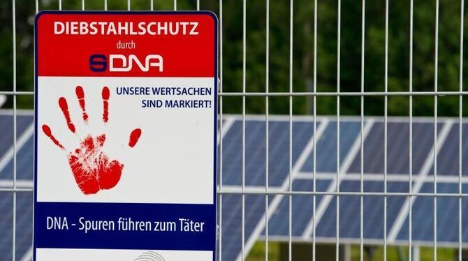 Ein Schild am Solarpark in Senftenberg (Brandenburg) weist auf den Diebstahlschutz der Solarmodule durch eine künstliche High