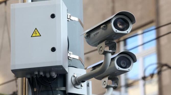 Zwei Videokameras hängen an einem Laternenpfahl. Foto: Roland Weihrauch/Illustration